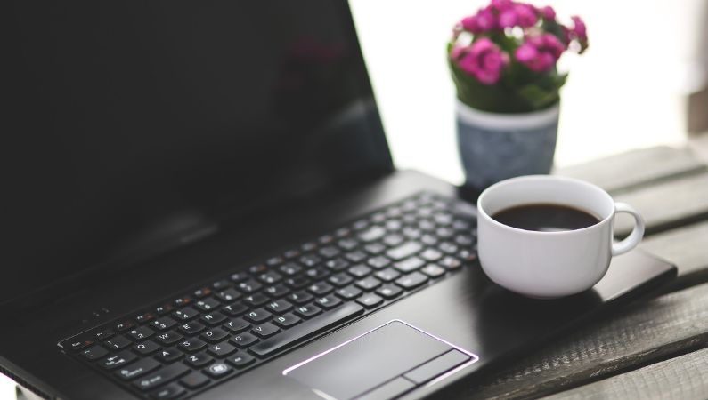 black laptop pink flower coffee